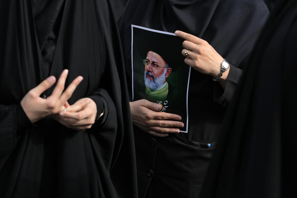 FILE - An Iranian woman holds a poster of the late President Ebrahim Raisi during a mourning ceremony for him at Vali-e-Asr square in downtown Tehran, Iran on May 20, 2024. While the cause of the May 19 crash remains unknown, the sudden death of the hard-line protégé of Iranian Supreme Leader Ayatollah Ali Khamenei exposed the contradictions and challenges facing the country's Shiite theocracy. (AP Photo/Vahid Salemi, File)