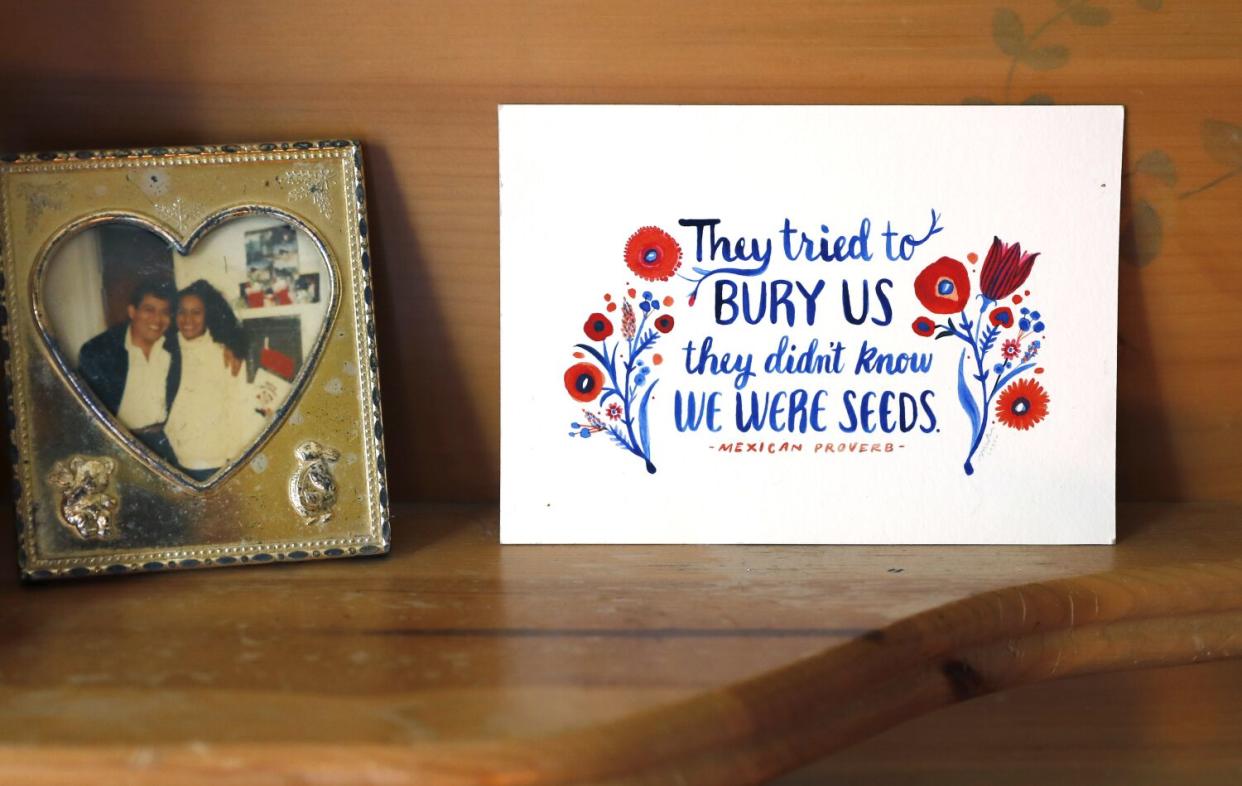 A family photograph sits beside a card gifted to Alejandra by her bosses.