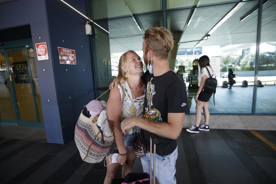 Andrea Monti hugs his girlfriend Katherina Scherf who just arrived from Duesseldorf, Germany at Rome's Fiumicino airport, Wednesday, June 3, 2020. Rome’s Fiumicino airport sprang back to life on Wednesday as Italy opened regional and international borders in the final phase of easing its long coronavirus lockdown, allowing families and loved ones separated by the global pandemic to finally reunite. (AP Photo/Alessandra Tarantino)