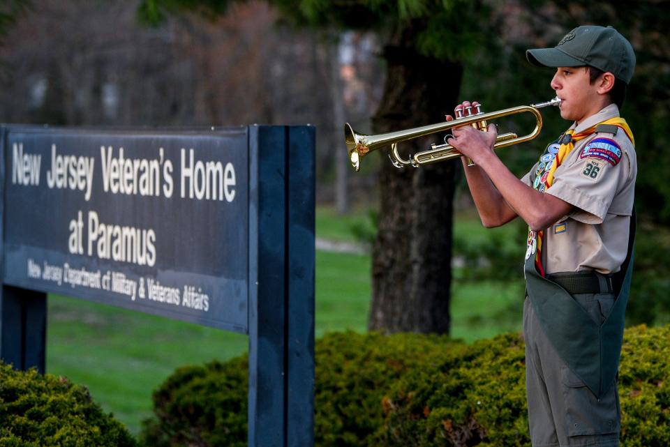 Alex Saldana, 13, a Boy Scout in Oradell Troop 36 and a Life Scout, plays the Marine Corps Hymn and Taps in front of the New Jersey Veterans Home in Paramus on Thursday April 09, 2020. Saldana plays to honor the 37 military veterans who have died at the the New Jersey Veteran's Home in the past two weeks. At least 10 veterans died from the coronavirus. 