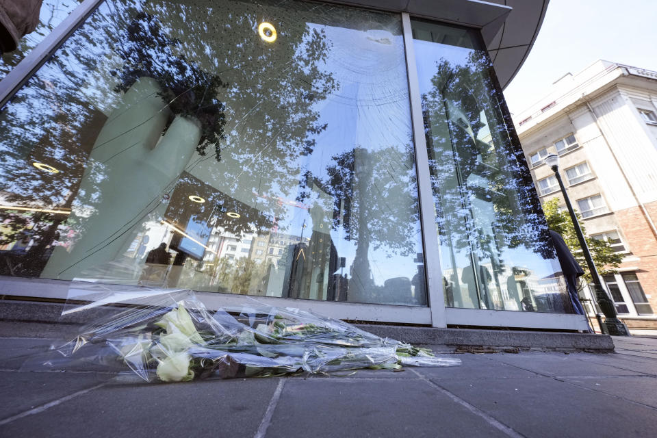 Flowers laid in tribute outside an office building in Brussels, Tuesday, Oct. 17, 2023, close to where two Swedish soccer fans were shot by a suspected Tunisian extremist on Monday night. Police in Belgium have shot dead a suspected Tunisian extremist accused of killing two Swedish soccer fans in a brazen attack on a Brussels street before disappearing into the night on Monday. (AP Photo/Martin Meissner)