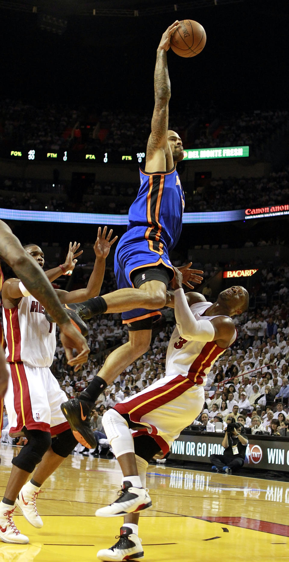 MIAMI, FL - MAY 09: Center Tyson Chandler #6 of the New York Knicks commits a charge against Guard Dwyane Wade #3 of the Miami Heat in Game Five of the Eastern Conference Quarterfinals in the 2012 NBA Playoffs on May 9, 2012 at the American Airines Arena in Miami, Florida.