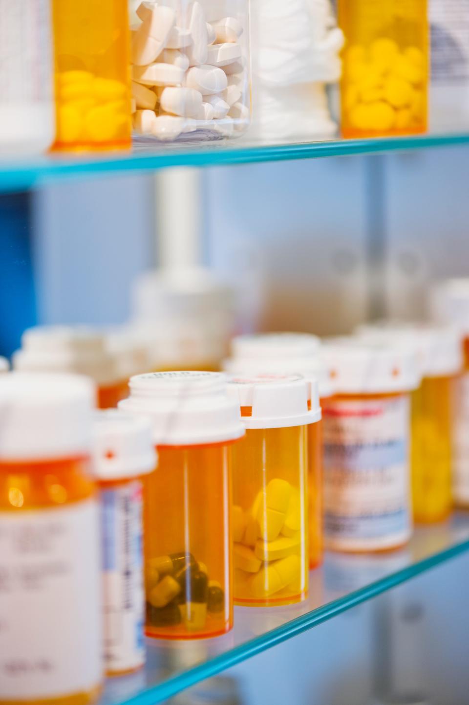 Pill bottles on a shelf in a medicine cabinet