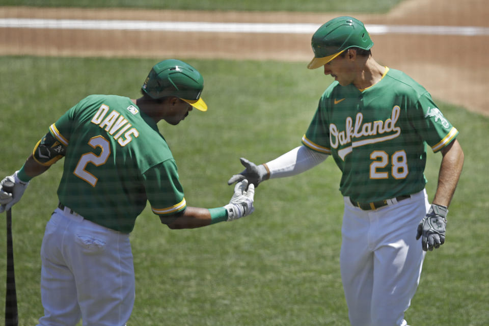 Oakland Athletics' Matt Olson (28) celebrates with Khris Davis, left, after hitting a home run off Texas Rangers' Mike Minor in the second inning of a baseball game Thursday, Aug. 6, 2020, in Oakland, Calif. (AP Photo/Ben Margot)