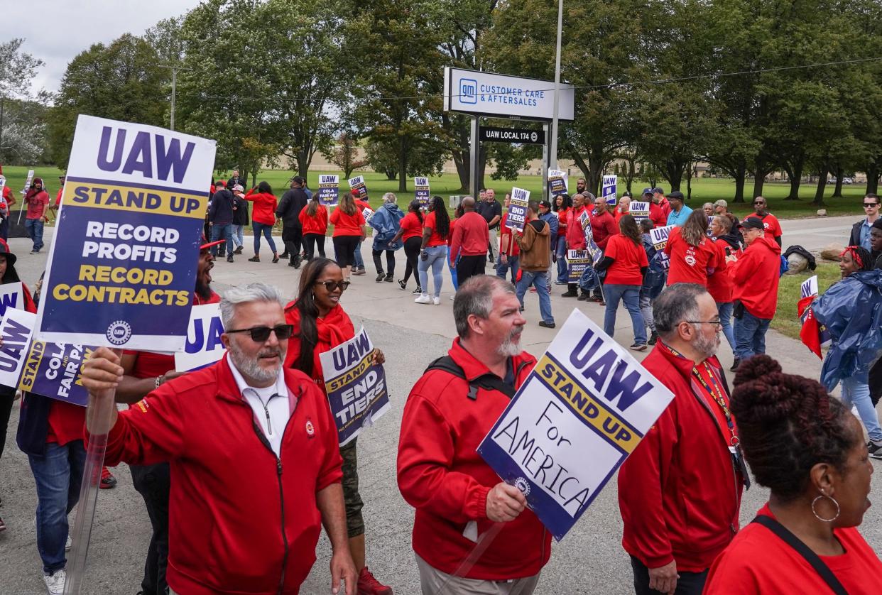 Workers walk in a circle while picketing at General Motors Willow Run Redistribution in Belleville on Sept. 26, 2023, as President Joe Biden arrives during his stop to Michigan.