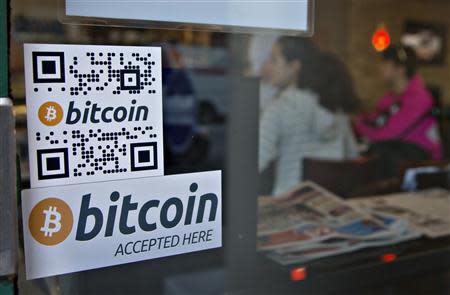 Signs on window advertise a bitcoin ATM machine that has been installed in a Waves Coffee House in Vancouver, British Columbia October 28, 2013. REUTERS/Andy Clark
