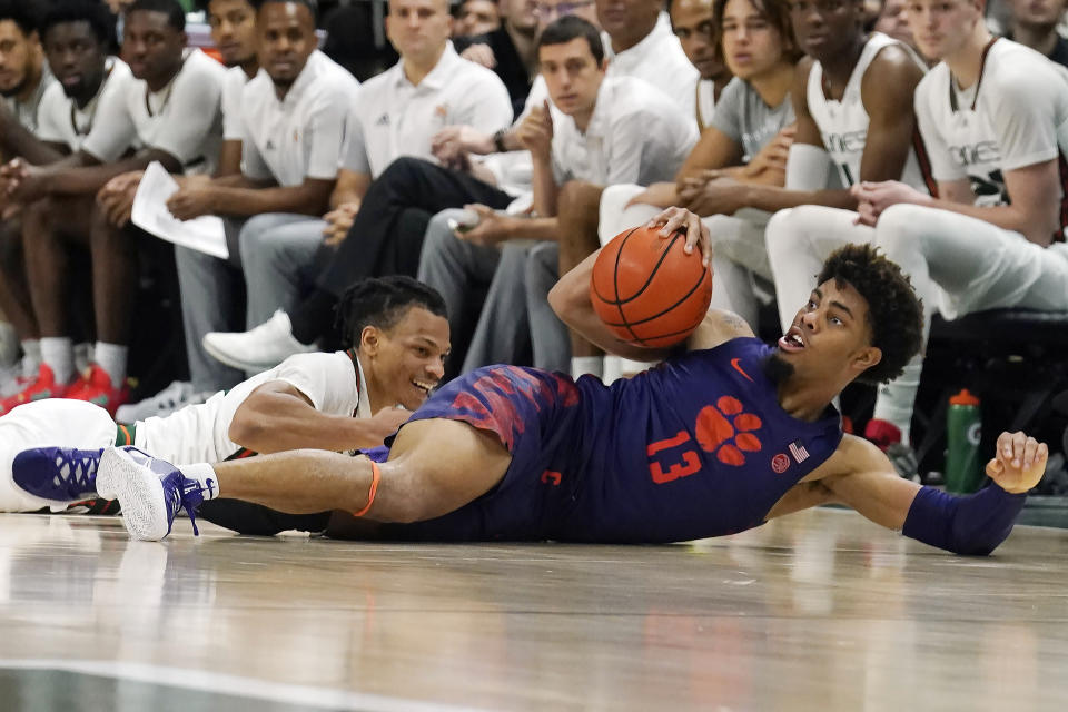 Clemson guard David Collins (13) gains control of a loose ball against Miami guard Isaiah Wong during the second half of an NCAA college basketball game, Saturday, Dec. 4, 2021, in Coral Gables, Fla. (AP Photo/Marta Lavandier)