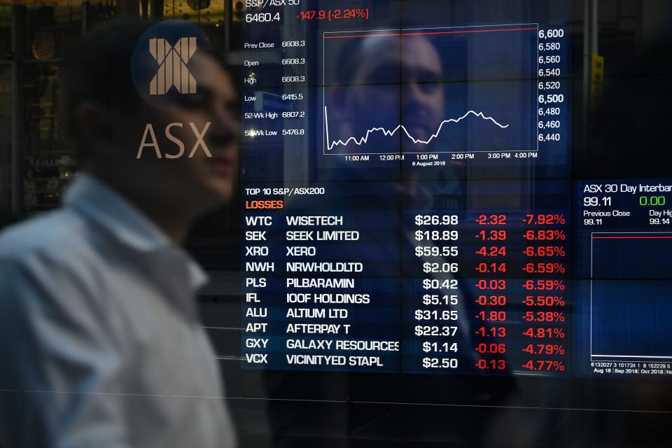 A man looking at stocks prices on an electronic screen. (Source: Getty)