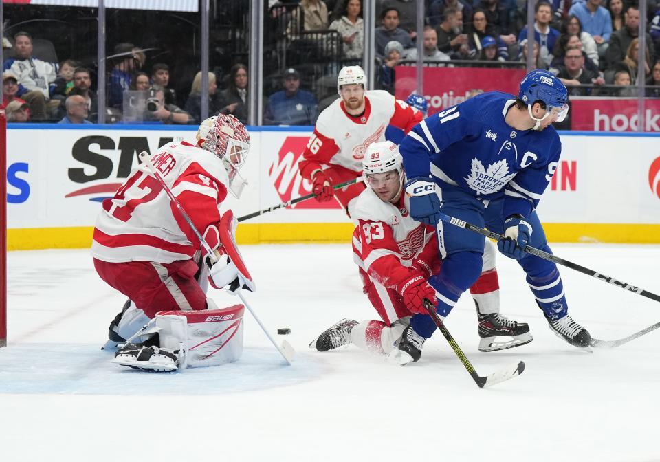 Red Wings right wing Alex DeBrincat battles for the puck with Maple Leafs center John Tavares during the first period on Saturday, April 13, 2024, in Toronto.
