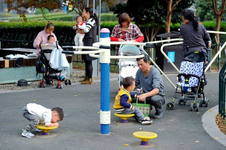 FILE PHOTO: People play with children at a park in Jinhua, Zhejiang province, China November 5, 2018. REUTERS/Stringer/File Photo