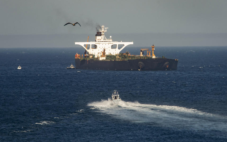 A supertanker hosting an Iranian flag is seen on the water in the British territory of Gibraltar, Sunday, Aug. 18, 2019. Authorities in Gibraltar on Sunday rejected the United States' latest request not to release a seized Iranian supertanker, clearing the way for the vessel to set sail after being detained last month for allegedly attempting to breach European Union sanctions on Syria. (AP Photo/Marcos Moreno)