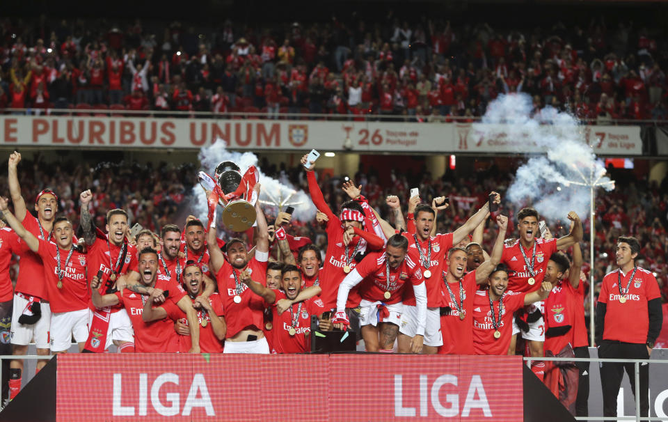 Benfica head coach Bruno Lage, right, watches as team captain Jardel lifts the trophy after the Portuguese league last round soccer match between Benfica and Santa Clara at the Luz stadium in Lisbon, Saturday, May 18, 2019. Benfica won 4-1 to clinch the championship title. (AP Photo/Armando Franca)