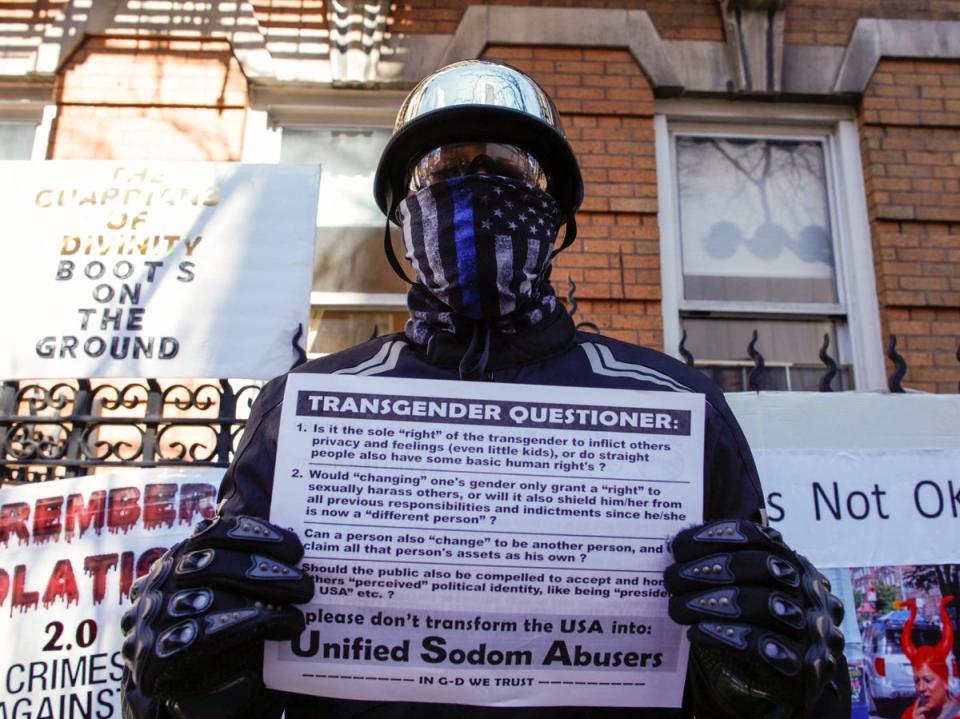 A member of the Proud Boys holds a ‘Transgender Questioner’ as he protests across supporters of Drag Story Hour outside the LGBTQ centre in New York City (AFP via Getty Images)