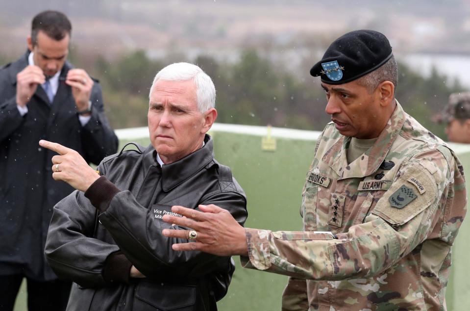 U.S. Vice President Mike Pence, left, is briefed by U.S. Gen. Vincent Brooks, right in the Demilitarized Zone (DMZ), near the border village of Panmunjom, South Korea, Monday, April 17, 2017.