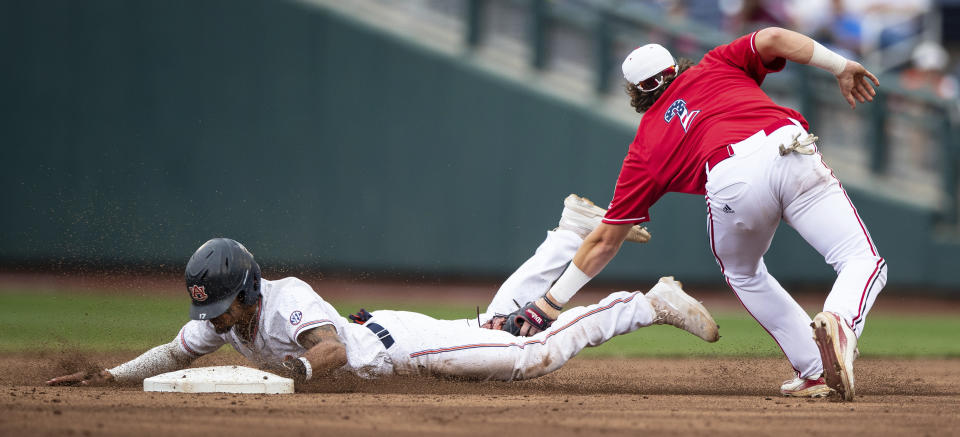Auburn's Will Holland, left, steals second base as Louisville's Tyler Fitzgerald misses the tag in the third inning. (Ryan Soderlin/Omaha World-Herald via AP)