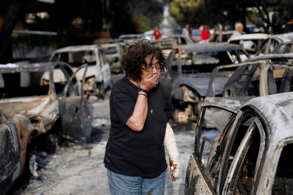 A woman reacts as she tries to find her dog, following a wildfire at the village of Mati. Source: Reuters