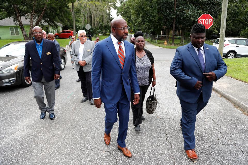 U.S. Senator Rev. Raphael Warnock walks with Garden City council members Natalyn Bates Morris District 3 and Richard Lassiter District 4, as well as Mayor Pro Tem Bruce Campbell and Mayor Don Bethune during a visit to the Rossignol Hill neighborhood to unveil a new package of housing legislation.