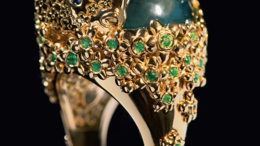 a gold and green jeweled ring