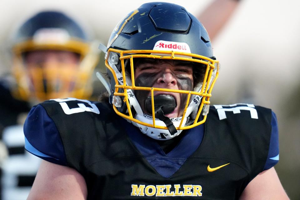 Moeller Crusaders linebacker Alex French (33) reacts after collecting a fumble from St. Xavier Bombers quarterback Daniel Vollmer (3) and scores in the first half of a high school football game Friday, Sept. 15, 2023, at Welcome Stadium in Dayton, Ohio.