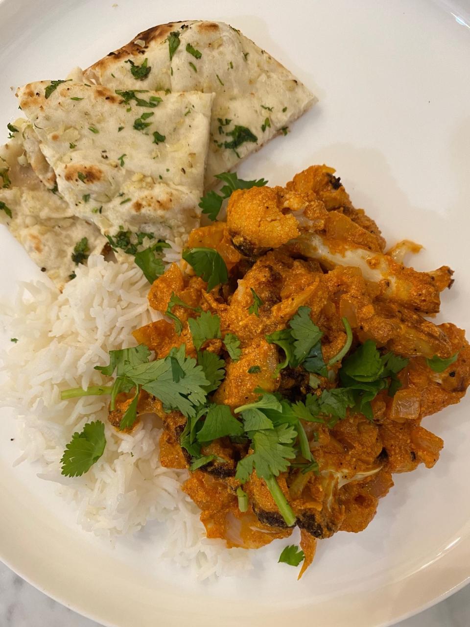 Butter cauliflower over rice with naan.