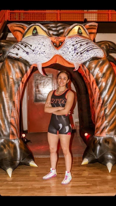 Aztec High School junior Makayla Munoz, shown here before the start of a recent tournament, is seeking her third straight state championship in girls wrestling.