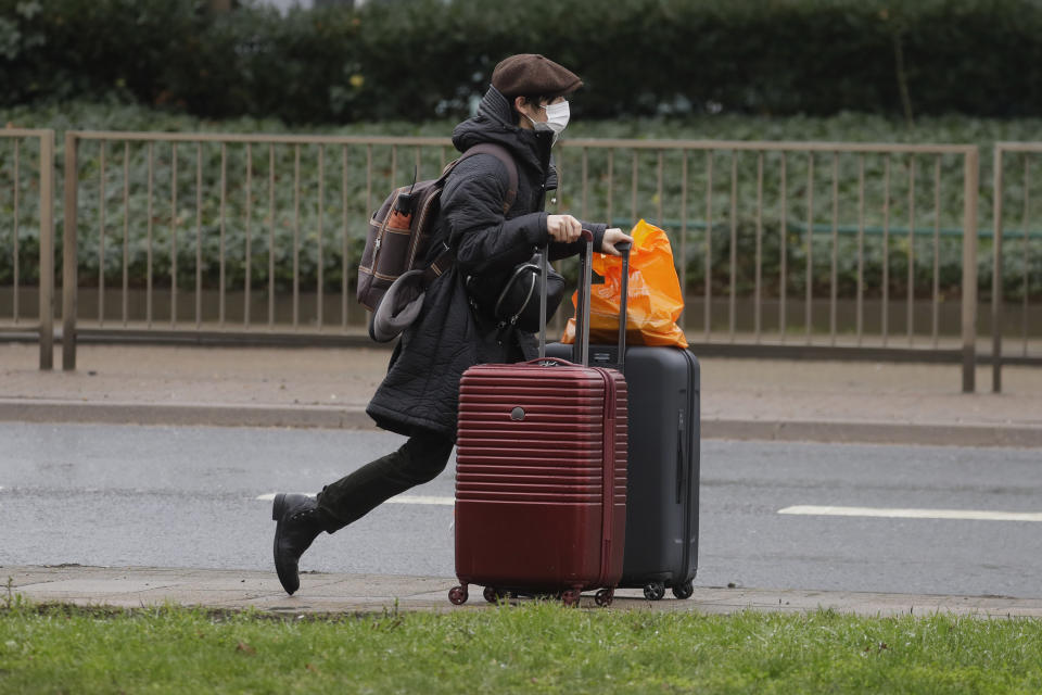 <p>A traveller walks with luggage near London's Heathrow Airport, Tuesday Feb. 16, 2021. New regulations require people arriving from one of the "coronavirus red list" countries to quarantine at one of the Government's managed quarantine hotel facilities.(AP Photo/Kirsty Wigglesworth)</p>
