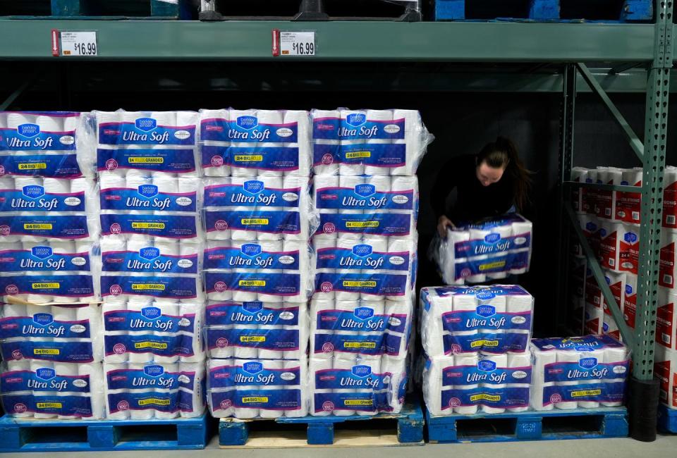 Jae Wilson rearranges bulk packages of toilet paper getting ready for the Friday opening of BJ's Market in Warwick.