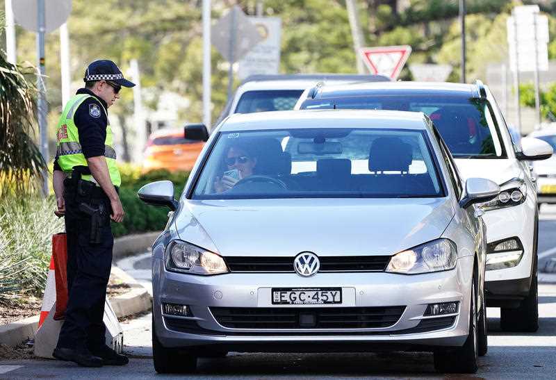 Motorists are seen at a checkpoint at Coolangatta on the Queensland- New South Wales border.