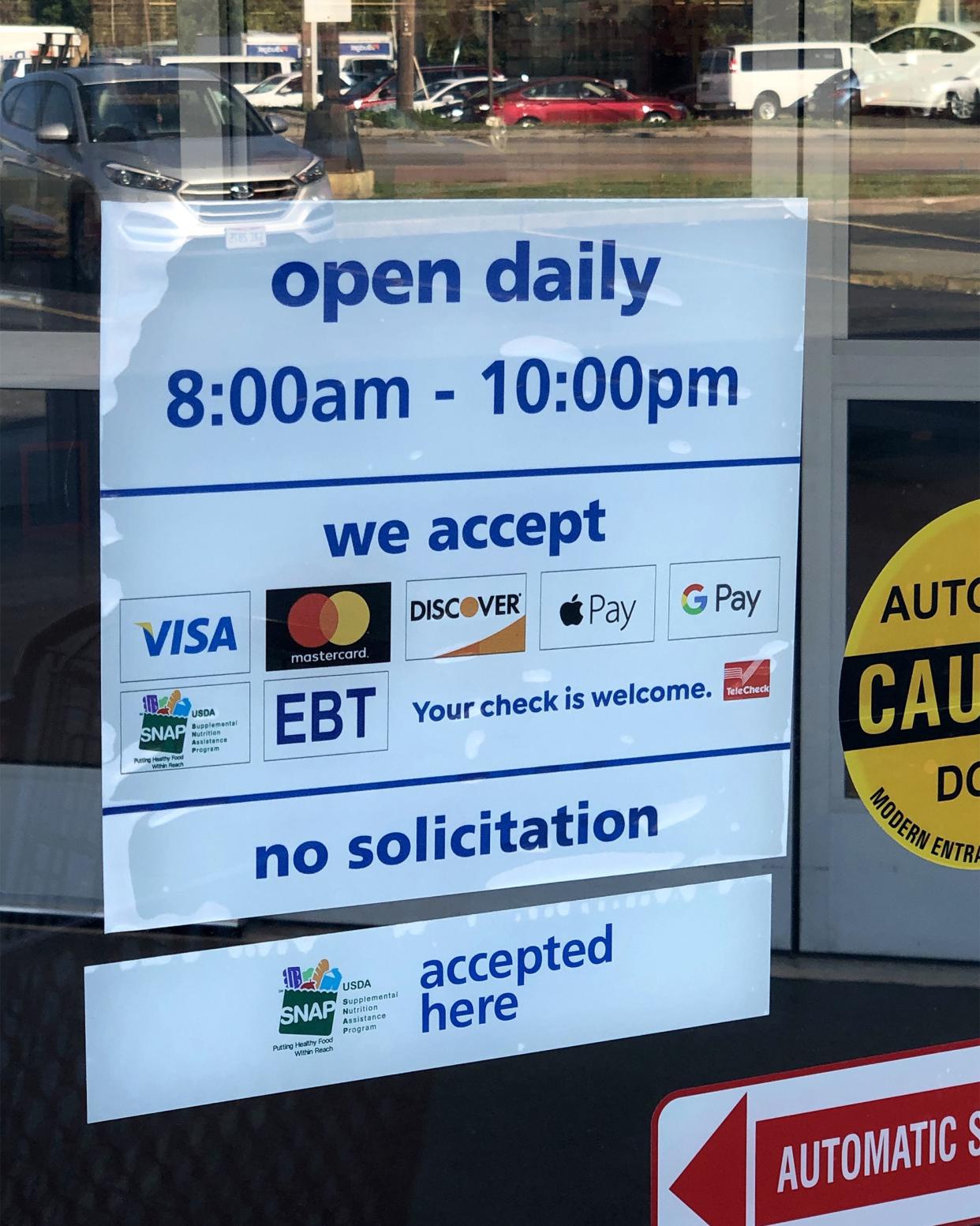 Open daily sign with payment accepted on front door of Save A Lot