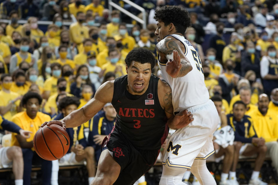 San Diego State guard Matt Bradley (3) drives on Michigan guard Eli Brooks (55) in the first half of an NCAA college basketball game in Ann Arbor, Mich., Saturday, Dec. 4, 2021. (AP Photo/Paul Sancya)