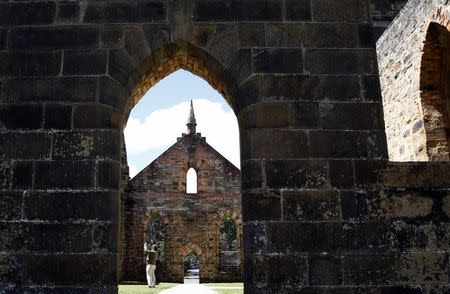 A tourist takes a photograph of the inside of an old church at the historical town of Port Arthur, located southeast of the capital city of Hobart December 26, 2014. REUTERS/Matt Siegel