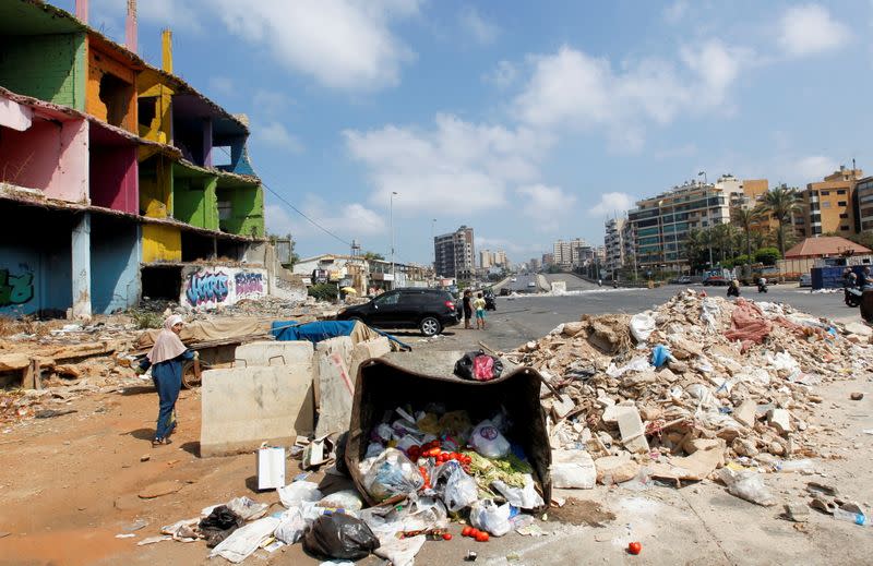 FILE PHOTO: People make their way through a road blocked by protestors as fuel crisis worsens, in Beirut