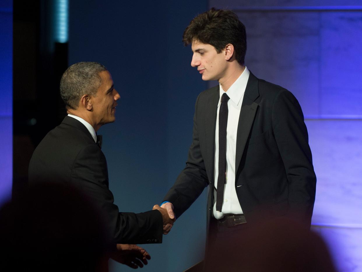 Barack Obama shakes hands with Jack Schlossberg after he introduced Obama during a dinner in honor of the Medal of Freedom awardees at the Smithsonian National Museum of American History on November 20, 2013