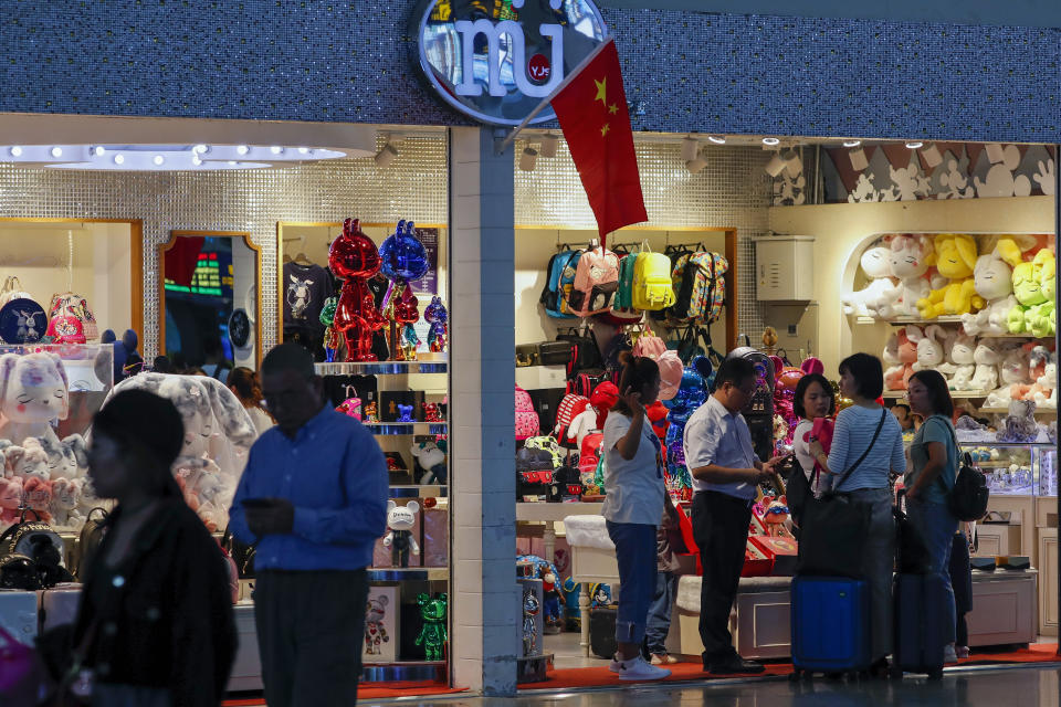 Passengers shop at the Shanghai Disney flagship store at the Hongqiao Railway Station in Shanghai, China, Monday, Oct. 14, 2019. China's trade with the United States fell by double digits again in September amid a tariff war that threatens to tip the global economy into recession. (AP Photo/Andy Wong)