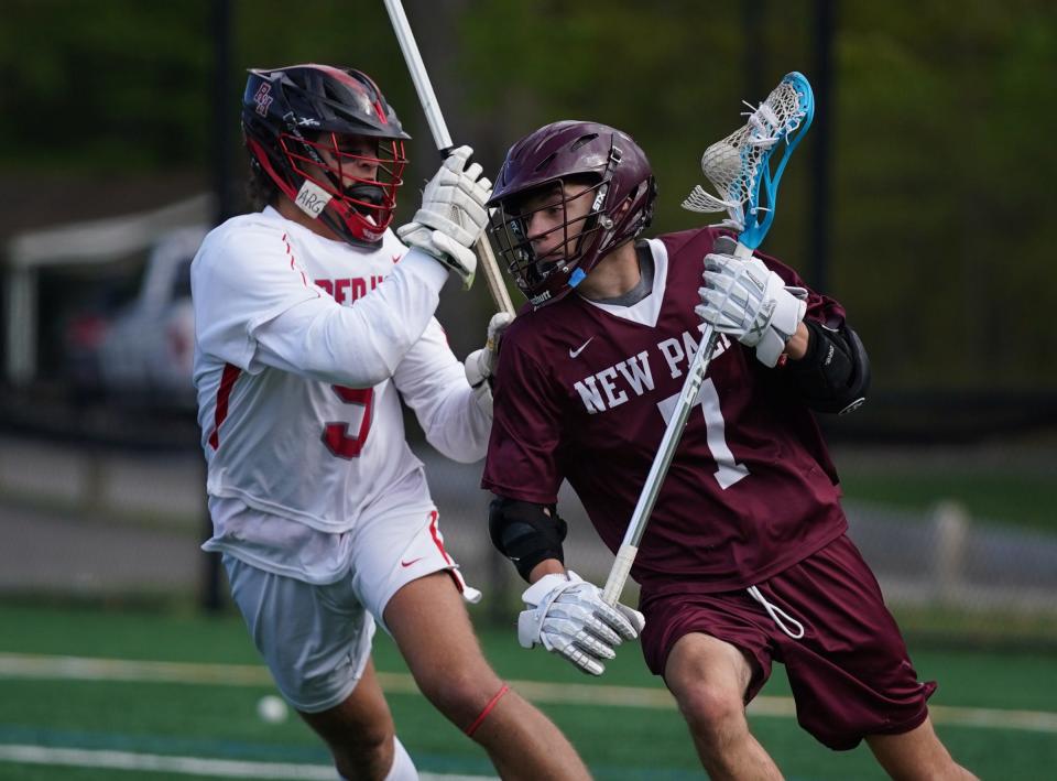 Red Hook's Gabe Gravino (5) defends as New Paltz's Oscar Cline (7) works towards the goal in boys lacrosse action at Bard College in Annandale-on-Hudson on Wednesday, May 3, 2023. 