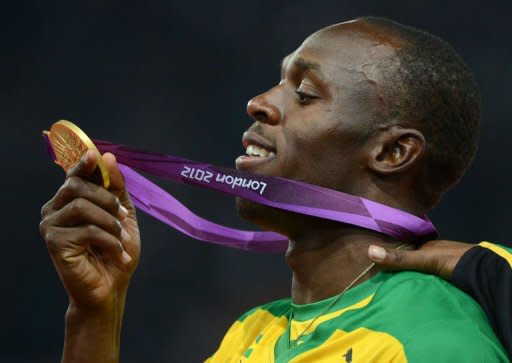 Gold medallist Jamaica's Usain Bolt looks at his gold medal on the podium after the men's 200m final at the athletics event during the London 2012 Olympic Games on August 9, 2012 in London