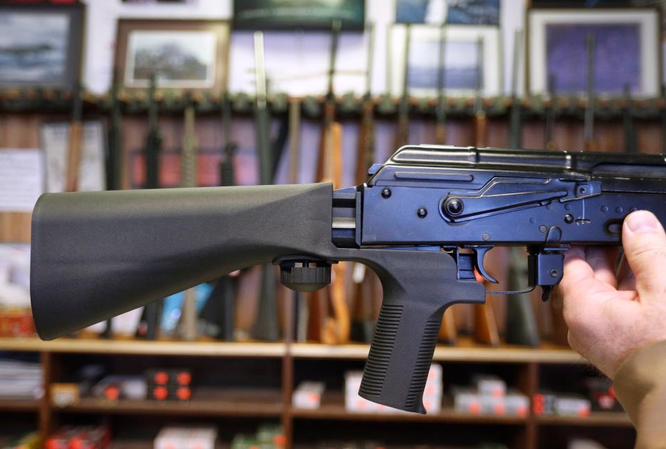 A bump stock device that fits on a semi-automatic rifle to increase the firing speed, making it similar to a fully automatic rifle, is installed on an AK-47 semi-automatic rifle at a gun store in Salt Lake City, Utah.