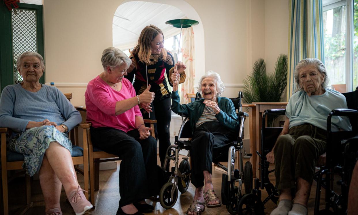 <span>Mary Griffin, 93, spins a plate, helped by circus performer Jasmin Edwards, at Castle Dene residential and dementia care in Bournemouth.</span><span>Photograph: Ben Birchall/PA</span>