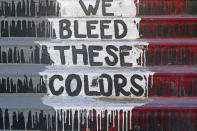 The phrase "We Bleed These Colors" is shown along a walkway which leads from the Bountiful High School parking lot up to the football field Tuesday, July 28, 2020, in Bountiful, Utah. While advocates have made strides in getting Native American symbols and names changed in sports, they say there's still work to do mainly at the high school level, where mascots like Braves, Indians, Warriors, Chiefs and Redskins persist. (AP Photo/Rick Bowmer)