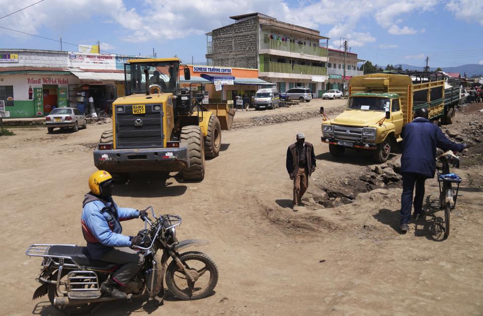 Construction vehicles are visible in Ndunyu Njeru, Kenya, Jan. 25, 2024. Following pressure from the Kenyan President, the environment authority has issued a license for the construction of a tarmac road through the Aberdare forest and mountain range to connect two counties. Supporters of the project say it will bring economic development and improve livelihoods. (AP Photo/Brian Inganga)