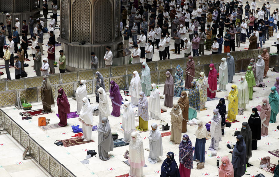 Indonesian Muslims pray spaced apart as they practice social distancing to curb the spread of the new coronavirus during an evening prayer called "tarawih" marking the first eve of the holy fasting month of Ramadan at Istiqlal Mosque in Jakarta, Indonesia. Monday, April 12, 2021. During Ramadan, the holiest month in Islamic calendar, Muslims refrain from eating, drinking, smoking and sex from dawn to dusk. (AP Photo/ Achmad Ibrahim)