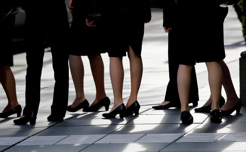 FILE PHOTO: Female office workers wearing high heels, clothes and bags of the same colour are seen at a business district in Tokyo