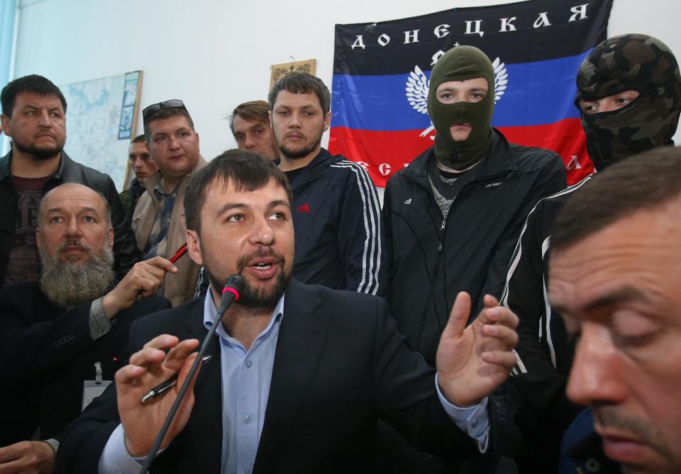 Denis Pushilin, foreground center, spokesman of the self-appointed Donetsk People’s Republic, speaks to reporters inside the regional administration building seized earlier in Donetsk, Ukraine, Friday, April 18, 2014. Pushilin told reporters that the insurgents do not recognize the Ukrainian government as legitimate. Pro-Russian insurgents in Ukraine’s east who have been occupying government buildings in more than 10 cities said Friday they will only leave them if the interim government in Kiev resigns.(AP Photo/Sergei Grits)