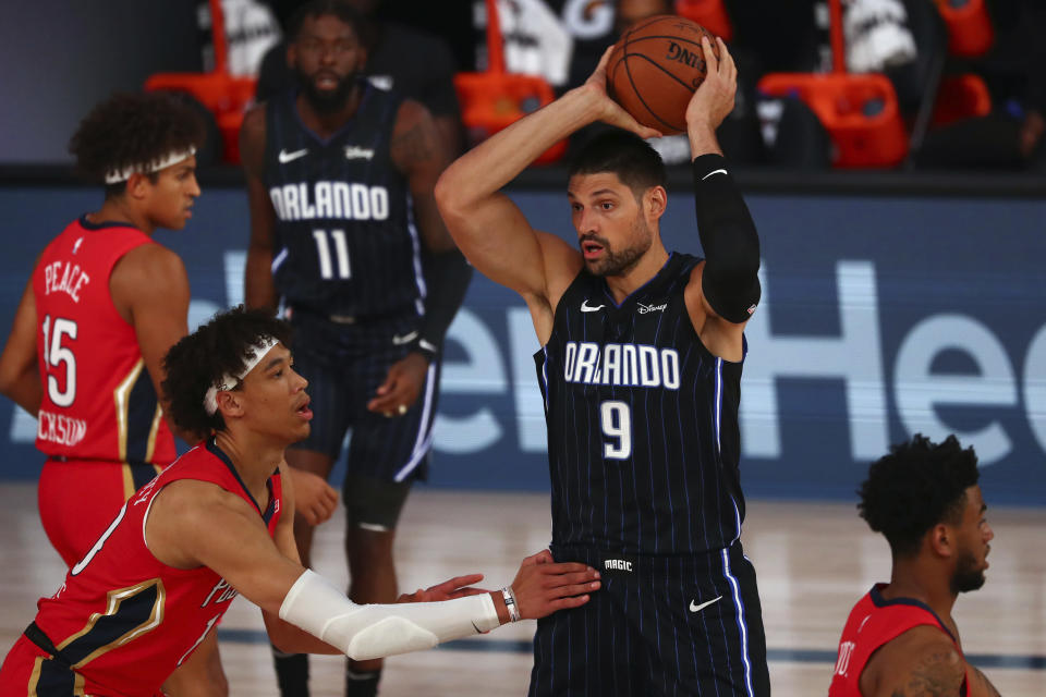 Orlando Magic center Nikola Vucevic (9) controls the ball against New Orleans Pelicans center Jaxson Hayes, front left, during the first half of an NBA basketball game Thursday, Aug. 13, 2020, in Lake Buena Vista, Fla. (Kim Klement/Pool Photo via AP)