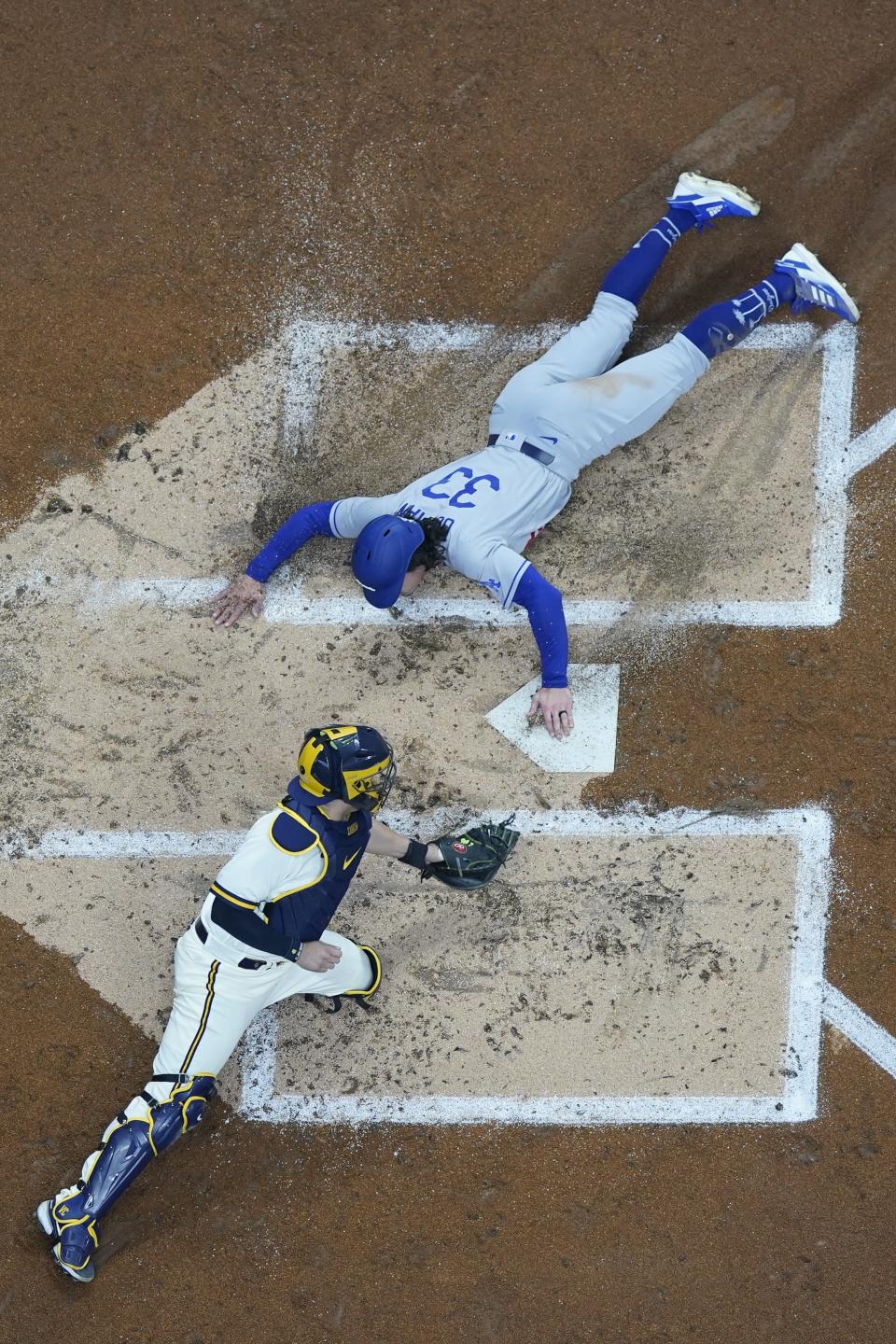 Los Angeles Dodgers' James Outman scores safely past Milwaukee Brewers catcher Victor Caratini during the second inning of a baseball game Tuesday, May 9, 2023, in Milwaukee. Outman scored from second on a hoit by Miguel Rojas. (AP Photo/Morry Gash)