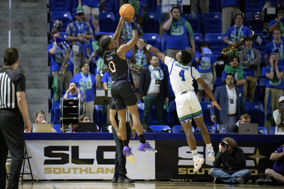 Northwestern State guard Demarcus Sharp (0) makes a three point basket Texas A&M Corpus Christi guard Jalen Jackson (4) during the first half an NCAA college basketball game in the finals of the Southland Conference men's tournament in Lake Charles, La., Wednesday, March 8, 2023. (AP Photo/Matthew Hinton)