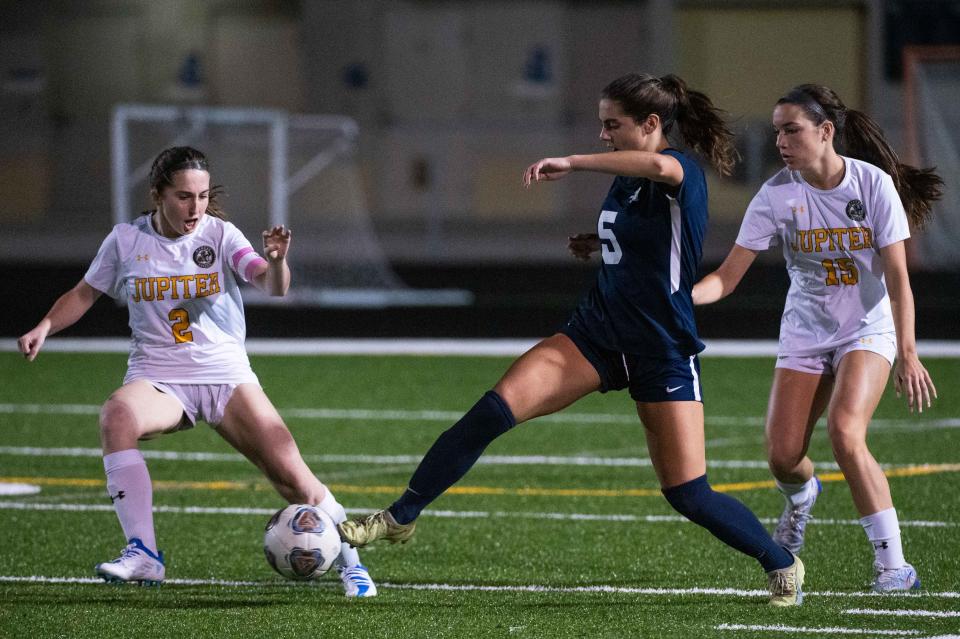 Boca Raton forward Laine Willis (5) dribbles the ball as Jupiter's Malloy Mauch (2) and Beatriz Pinto (15) pressure during the second half of the game between Jupiter and host Boca Raton on Tuesday, January 17, 2023, in Boca Raton, FL. Final score, Boca Raton, 2, Jupiter, 1.