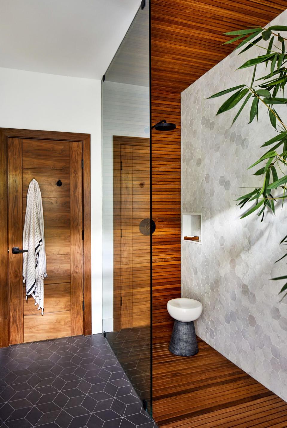 vacation home in maui, hawaii designed by breeze giannasio interiors guest bath with teak wrapped walls, this room opens to the pool area via a connected outdoor shower wall tile tile stool made goods showerhead california faucets floor tile mutina towel hooks signature hardware
