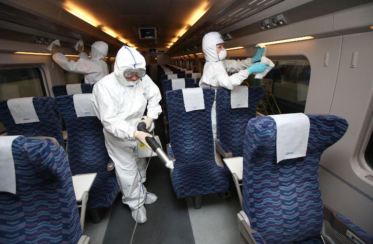 Workers disinfect a train carriage at a station in Seoul, on June 7, 2015
