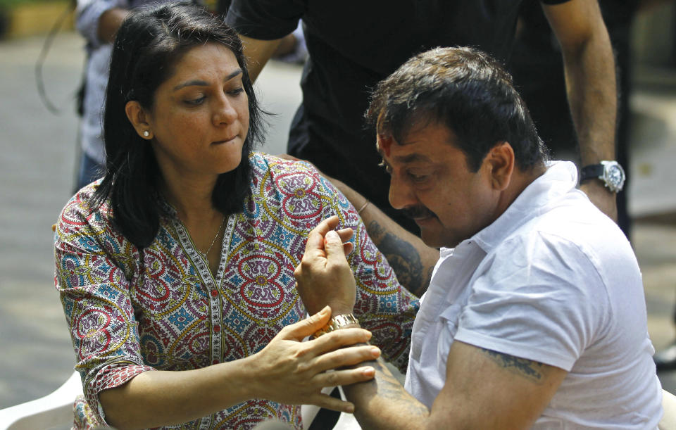 Indian Bollywood actor Sanjay Dutt, right, breaks down as his sister Priya Dutt tries to console him during a press conference at his residence in Mumbai, India, Thursday, March 28, 2013. Dutt said he has not sought pardon for a 1993 weapons conviction and will serve his prison sentence as ordered by India's Supreme Court. Dutt broke his silence a week after the court sentenced him to five years in prison for illegal possession of weapons supplied by Mumbai crime bosses linked to a 1993 terror attack that killed 257 people. (AP Photo/Rafiq Maqbool)